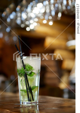 Mojito cocktail with straw on the bar. Close-up, selective focus. 80489317