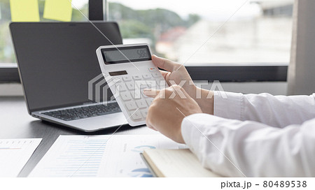 Businessman presses a calculator to calculate earnings and analyze company earnings in his private office, Information in finance and accounting, Company performance and revenue. 80489538