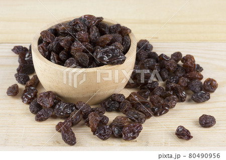 raisins in bowl on wooden table. 80490956