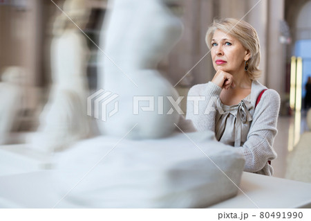 Adult female looking at artwork sculpture in the museum indoors 80491990
