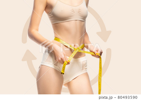 Young tanned slim girl taking measurements of her body isolated on colored background. Collage. 80493590