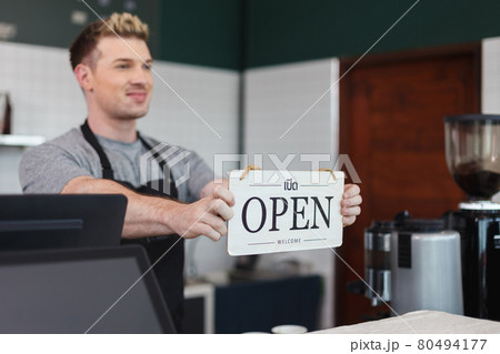 men barista holding sign wooden text open, welcome entrance shop. 80494177