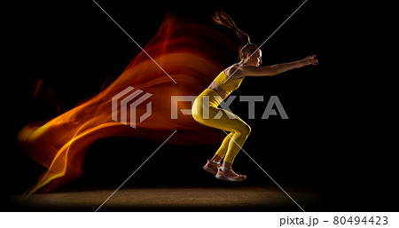 Flyer. Young woman, female athlete training isolated over black studio background in mixed neon lights. Side view Flyer. Young woman, female athlete training isolated over black studio background in mixed neon lights. Side view 80494423