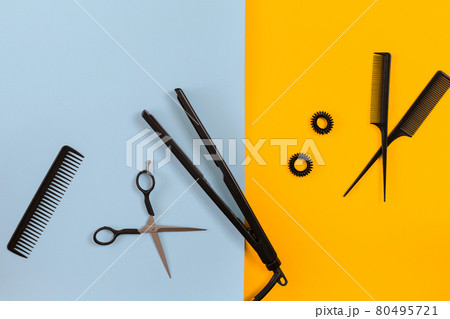 Various hair styling devices on the color blue, yellow paper background, top view Various hair styling devices on the color blue, yellow paper background, top view 80495721