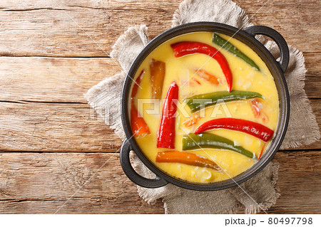 Spicy Ema datshi the national dish of Bhutan is an easy to make hearty soup with chilli peppers and cheese closeup in the pan. horizontal top view 80497798