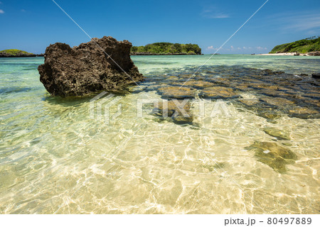 Gorgeous crystalline emerald green sea beach, coastal rocks, blue sky. Iriomote Island. 80497889