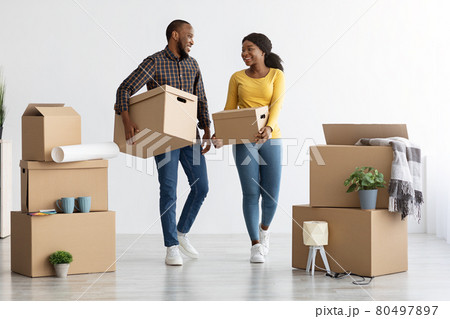Home Relocation Concept. Joyful African American Spouses Walking With Cardboard Boxes 80497897
