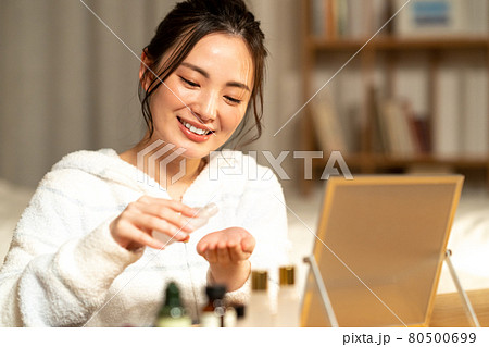 夜に肌のお手入れをする若い女性 80500699