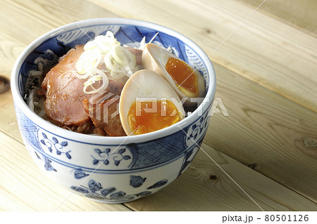 キャベツの千切りに味玉、ネギがトッピングされた湯気立つ焼豚丼 80501126