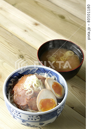 キャベツの千切りに味玉、ネギがトッピングされた湯気立つ焼豚丼と味噌汁のセット キャベツの千切りに味玉、ネギがトッピングされた湯気立つ焼豚丼と味噌汁のセット 80501180