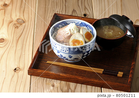 キャベツの千切りに味玉、ネギがトッピングされた湯気の立つ焼豚丼と味噌汁のセット キャベツの千切りに味玉、ネギがトッピングされた湯気の立つ焼豚丼と味噌汁のセット 80501211