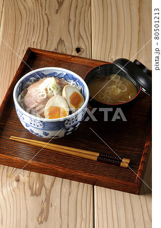 キャベツの千切りに味玉、ネギがトッピングされた湯気の立つ焼豚丼と味噌汁のセット キャベツの千切りに味玉、ネギがトッピングされた湯気の立つ焼豚丼と味噌汁のセット 80501213