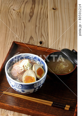 キャベツの千切りに味玉、ネギがトッピングされた湯気の立つ焼豚丼と味噌汁のセット キャベツの千切りに味玉、ネギがトッピングされた湯気の立つ焼豚丼と味噌汁のセット 80501214