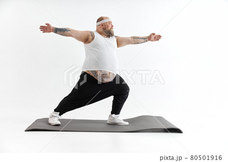 Sporty fat man with beard and tattoos is doing yoga 80501916