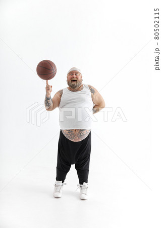 bearded fat caucasian tattoed man with basketball ball in white background. He is funny and happy 80502115
