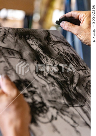 Close up of artists hand painting with graphite crayon 80502266