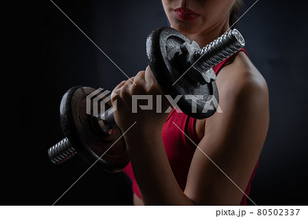 A woman is exercising and lifting weights. 80502337
