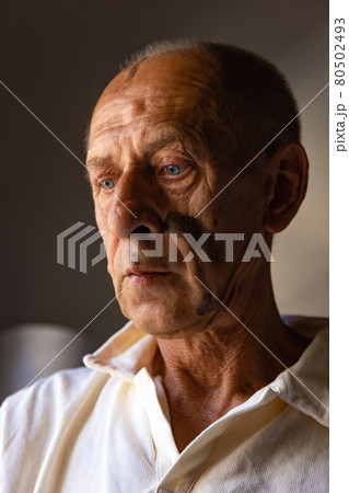 Mature or senior painter or artist with graphite crayon in front of camera. Man in a paint-stained shirt working at studio Mature or senior painter or artist with graphite crayon in front of camera. Man in a paint-stained shirt working at studio 80502493