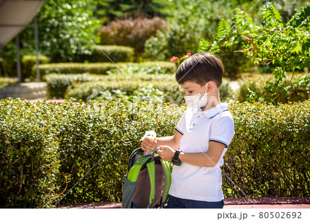 School child with backpack, face mask and sanitizer. Student safety after coronavirus pandemic. Virus and disease prevention for kids. Back to school and kindergarten after covid-19 outbreak 80502692
