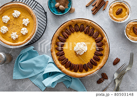 Pumpkin pie with cinnamon, pecan nuts and whipped cream for Thanksgiving, top view. Pumpkin pie with cinnamon, pecan nuts and whipped cream for Thanksgiving, top view. 80503148