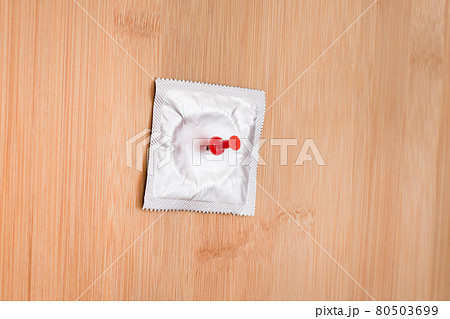 Packaged Latex Condom Pinned to a Wooden Message Board Packaged Latex Condom Pinned to a Wooden Message Board 80503699