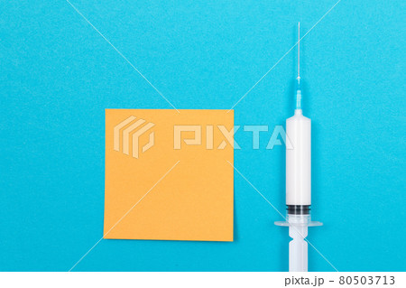 Vaccination or Revaccination Concept - A Medical Syringe on Blue Table 80503713