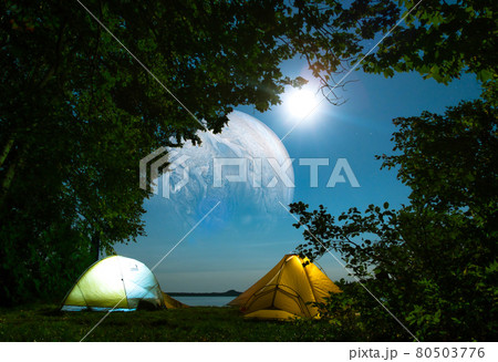 Camp in the forest at night, with a beautiful view of space and the moon Camp in the forest at night, with a beautiful view of space and the moon 80503776