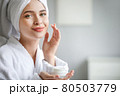 Beautiful woman with green eyes coming out of the bath with cream in her hands. 80503779