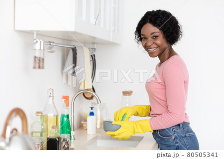 Happy black lady washing dishes, copy space 80505341
