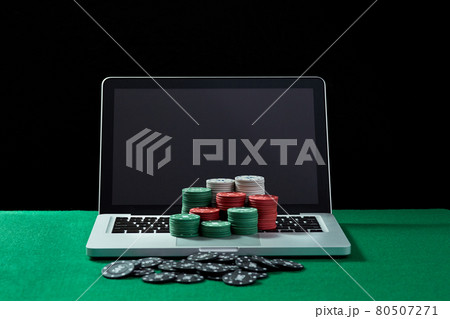 Casino chips on keyboard notebook at green table. Casino chips on keyboard notebook at green table. 80507271