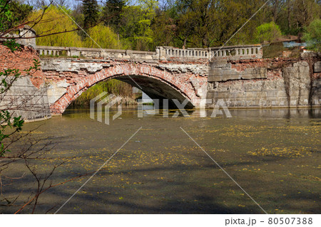 Old arched brick bridge across a pond in Sharovka Palace park in in Kharkov region, Ukraine Old arched brick bridge across a pond in Sharovka Palace park in in Kharkov region, Ukraine 80507388