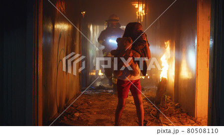 Fireman carrying kid heroically through smoke and fire Fireman carrying kid heroically through smoke and fire 80508110
