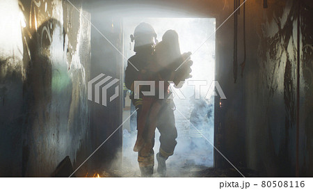 Fireman carrying kid heroically through smoke and fire Fireman carrying kid heroically through smoke and fire 80508116