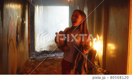 Terrified girl standing in burning building Terrified girl standing in burning building 80508120