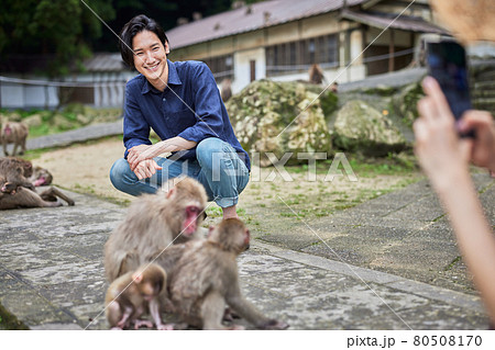 動物園デートでスマホで記念撮影する若いカップル 撮影協力 高崎山自然動物園 の写真素材