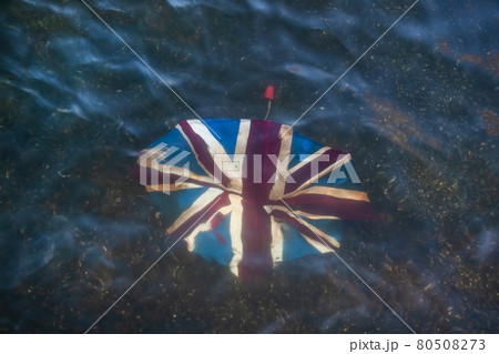 Broken umbrella with Union Jack on it, discarded in shallow river. Broken umbrella with Union Jack on it, discarded in shallow river. 80508273