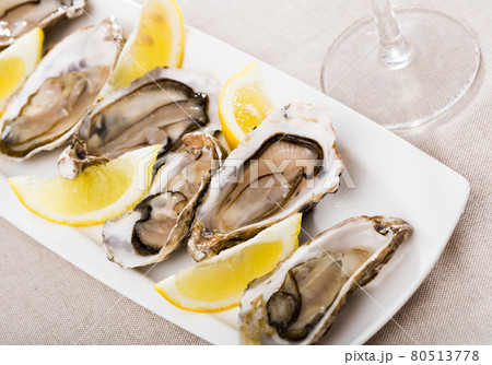Tasty oysters with lemon on plate top view Tasty oysters with lemon on plate top view 80513778