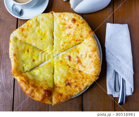Sliced Megrelian khachapuri with melted suluguni cheese Sliced Megrelian khachapuri with melted suluguni cheese 80516961