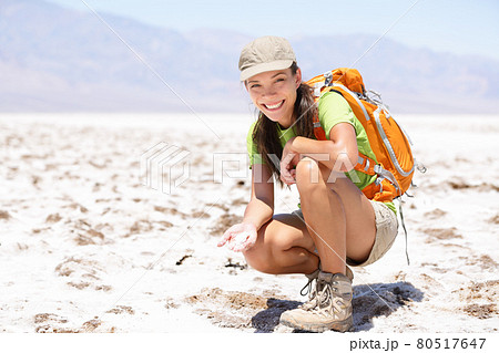 Death Valley. Hiker woman in Death Valley, California, USA showing dried out salt in Badwater Basin. 80517647