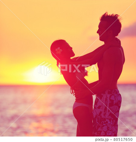 Romantic couple embracing kissing on beach sunset 80517650