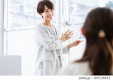 紙資料を手に持ち人前で話をするビジネスウーマン 80519842