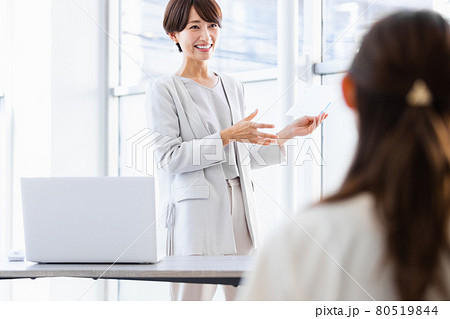 紙資料を手に持ち人前で話をするビジネスウーマン 80519844