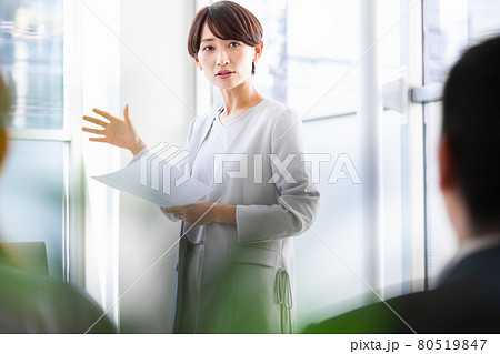 紙資料を手に持ち人前で話をするビジネスウーマン 80519847