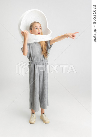 Portrait of little school caucasian girl in large helmet posing isolated over white studio background. Portrait of little school caucasian girl in large helmet posing isolated over white studio background. 80521023