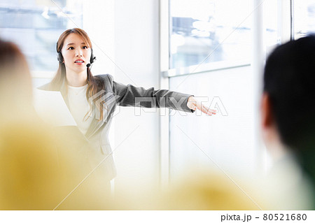 ヘッドセットをつけて人前で話をするビジネスウーマン 80521680