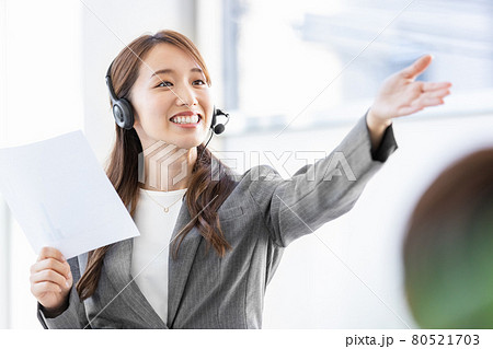 ヘッドセットをつけて人前で話をするビジネスウーマン 80521703