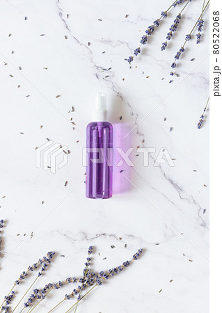 Bottle of skincare tonic water with dried lavender herbs top view on white marble background top view. 80522068