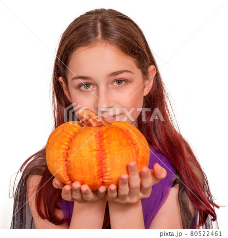Halloween concept. A young girl with a pumpkin in a Halloween costume isolate. 80522461