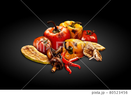 Grilled delicious red and yellow bell pepper, tomatoes, zucchini, champignons, chilli and halves of garlic on black background. Close up Grilled delicious red and yellow bell pepper, tomatoes, zucchini, champignons, chilli and halves of garlic on black background. Close up 80523456