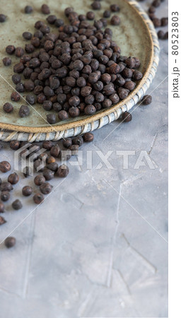 Plate of black chickpea on grey table closeup Plate of black chickpea on grey table closeup 80523803